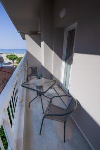 a balcony with two chairs and a table on it at studio 109 in Nei Poroi