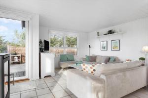 een woonkamer met een bank en een tafel bij LN1972-Hjorring-Hyttefadet-13 in Hjørring