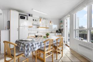 een keuken en eetkamer met een tafel en stoelen bij LN1972-Hjorring-Hyttefadet-13 in Hjørring