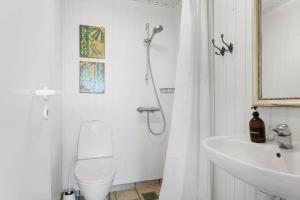 een badkamer met een douche, een toilet en een wastafel bij LN1972-Hjorring-Hyttefadet-13 in Hjørring +15 foto's