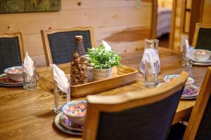 a wooden table with a table set with plates and glasses at Fireside in Broken Bow