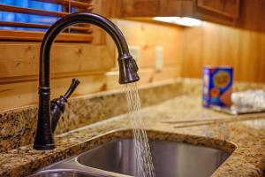 a kitchen sink with water coming out of a faucet at Fireside in Broken Bow +148 photos