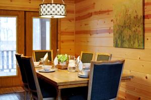 a dining room with a wooden table and chairs at Fireside in Broken Bow