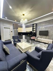 a living room with blue couches and a piano at BOULEVARD apartments in Tashkent