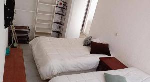 a bedroom with two twin beds and a couch at Pelicano House in Cancún
