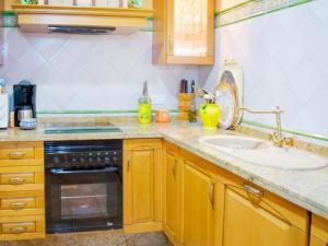 eine Küchentheke mit einer Spüle und einem Herd in der Unterkunft Seville Escape with Terrace in Sevilla