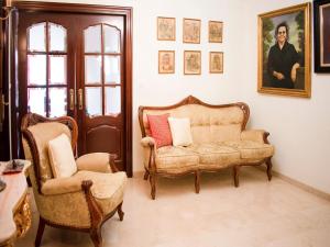 ein Wohnzimmer mit einer Couch und zwei Sesseln in der Unterkunft Seville Escape with Terrace in Sevilla