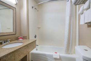 a bathroom with a sink and a tub and a toilet at Howard Johnson by Wyndham Malden Boston Area in Malden +33 photos