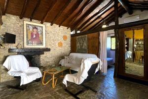 a living room with a fireplace and white chairs at Alojamiento Turístico Nacarum in El Palmar