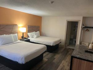 a hotel room with two beds and a bathroom at Howard Johnson by Wyndham Malden Boston Area in Malden