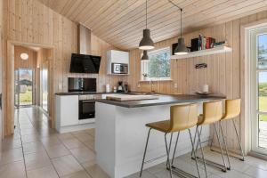 a kitchen with a counter and chairs in it at LN1931-Hjorring-Norre-Knoldevej-25 in Hjørring