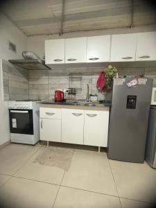 a kitchen with white cabinets and a stainless steel refrigerator at Deptosxdia in Perito Moreno