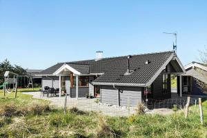 a house with a black roof and a yard at LN1900-Hirtshals-Kragekaeret-11 in Hirtshals