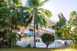 a building with palm trees in front of it at Phuket Arkadia Home in Nai Harn Beach