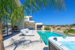 a villa with a swimming pool and a palm tree at Villa Trapezia Diamond in Kolymbia