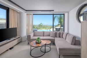 a living room with a couch and a tv at Villa Trapezia Diamond in Kolymbia