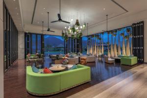 ein Wohnzimmer mit einem grünen Sofa und Stühlen in der Unterkunft Holiday Inn Resort Qionghai Guantang by IHG in Qionghai