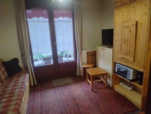 a living room with a couch and a window at 1 Bedroom flat, 5 min walk funicular Les Arcs & in city center, Parking, Wifi in Bourg-Saint-Maurice