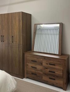 a bedroom with a dresser with a mirror on it at شقة الزمرد in Jeddah +9 photos