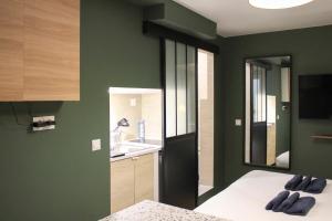 a bedroom with green walls and a sink and a bed at Studio 2 steps from the Musée Grévin in Paris