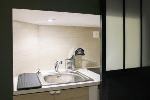a bathroom sink with a faucet and a mirror at Studio 2 steps from the Musée Grévin in Paris