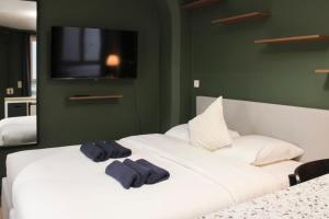 a bedroom with a white bed with two towels on it at Studio 2 steps from the Musée Grévin in Paris +4 photos