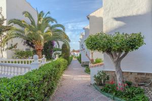 a walkway with trees and a white fence at Casa Nutt by the Sea in Torrox