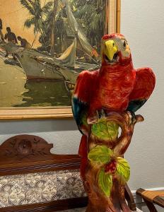 a statue of a parrot sitting on a tree branch at The Chaska House & Cottages in Waxahachie