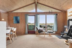 约灵LN1889-Hjorring-Soslangevej-31的客厅设有木墙和大窗户