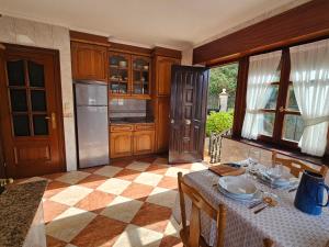 a kitchen with a table and a refrigerator at Casa Villadam in Ribadesella