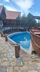 a swimming pool with a boat next to a house at Semeteška bajka in Raška