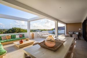 un salon avec une table et une grande fenêtre dans l'établissement Nieuwe luxe villa Blue Bay Resort, à Dorp Sint Michiel