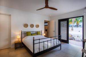 une chambre avec un lit et une porte coulissante en verre dans l'établissement Nieuwe luxe villa Blue Bay Resort, à Dorp Sint Michiel 33 autres photos