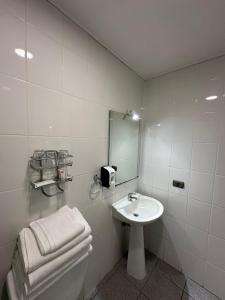 a bathroom with a sink and a toilet and a mirror at Hotel Casona Freire in Puerto Varas +28 photos