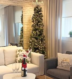 a christmas tree in a living room with a bottle of champagne at Casa Fuerte Playa in La Herradura