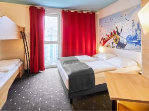 a hotel room with two beds and a window at B&B Hotel Mainz-Hbf in Mainz