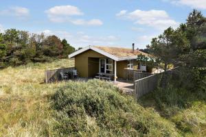 a small yellow house on a hill in a field at LN1957-Hirtshals-Fyrreklitten-4 in Hirtshals