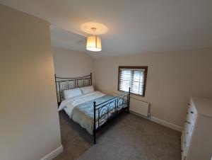 a bedroom with a bed and a window at 1 Top Locks Cottage in Burscough