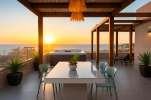 a patio with a table and chairs and a hot tub at See2sea Cozy Apartments in Kolymvari