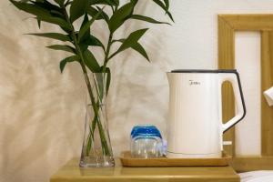 a vase with a plant sitting on a table at Zhuzhi Light Luxury B&B in Lijiang
