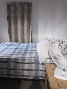 a bedroom with a bed with a fan on a table at Casa da Lika in Ilha de Boipeba