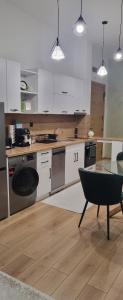 una cocina con armarios blancos y una mesa con una silla en Green apartment Velingrad, en Velingrad