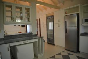 a kitchen with a stainless steel refrigerator and cabinets at Beach House AP in Miramar +9 photos