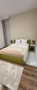 1 dormitorio con cama verde y almohadas blancas en Green apartment Velingrad, en Velingrad 40 fotos más