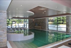 a swimming pool in a building with windows at Лари Б01 in Borovets