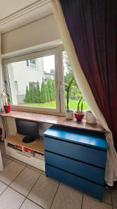 a room with a window and a blue dresser at Holiday Everyday - Urlaubsparadies mit 2 Fahrrädern in Hemer