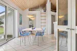 a dining room with a white table and blue chairs at LN1939-Hjorring-Nordsovej-35 in Hjørring