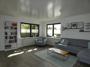 una sala de estar con un sofá y una mesa en fewo1846 - Haus Hygge - Bungalow mit Garten und 2 Schlafzimmern, en Flensburg