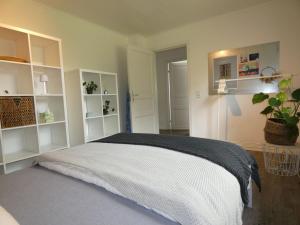 Un dormitorio con una cama con armarios blancos y una planta. en fewo1846 - Haus Hygge - Bungalow mit Garten und 2 Schlafzimmern, en Flensburg