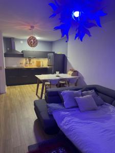 a living room with a bed and a table and a kitchen at Luxurious apartment in Auderghem in Brussels